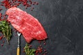 Raw Flank steak with rosemary and pink salt. Fresh Marble beef meat black Angus. Black background. Top view. Copy space Royalty Free Stock Photo