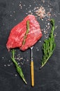 Raw Flat iron steak with rosemary and pink salt. Fresh Marble beef meat black Angus. Black background. Top view Royalty Free Stock Photo
