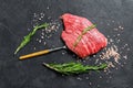 Raw Flat iron steak with rosemary and pink salt. Fresh Marble beef meat black Angus. Black background. Top view Royalty Free Stock Photo