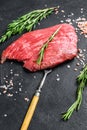 Raw Flat iron steak with rosemary and pink salt. Fresh Marble beef meat black Angus. Black background. Top view Royalty Free Stock Photo