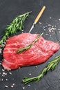 Raw Flat iron steak with rosemary and pink salt. Fresh Marble beef meat black Angus. Black background. Top view Royalty Free Stock Photo