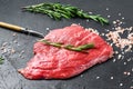 Raw Flat iron steak with rosemary and pink salt. Fresh Marble beef meat black Angus. Black background. Top view Royalty Free Stock Photo