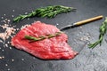 Raw Flat iron steak with rosemary and pink salt. Fresh Marble beef meat black Angus. Black background. Top view Royalty Free Stock Photo