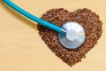 Raw flax seeds heart shaped and stethoscope Royalty Free Stock Photo