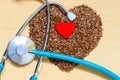 Raw flax seeds heart shaped and stethoscope Royalty Free Stock Photo