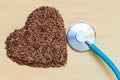 Raw flax seeds heart shaped and stethoscope Royalty Free Stock Photo