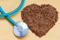 Raw flax seeds heart shaped and stethoscope Royalty Free Stock Photo