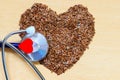 Raw flax seeds heart shaped and stethoscope Royalty Free Stock Photo