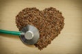 Raw flax seeds heart shaped and stethoscope Royalty Free Stock Photo