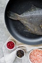 Raw flounder in the pan. Gray background, top view. Royalty Free Stock Photo