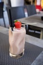 Raw food smoothie with strawberry and blackberry in crystal glass. No people. empty outdoor bar in grey. Waiting for