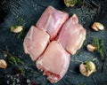 Raw Free range Boneless skinless chicken thighs with thime, garlic, red pepper corns and sea salt flakes on stone table Royalty Free Stock Photo