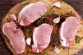 Raw Fresh Boneless Pork Chops with herbs. on wooden board. Royalty Free Stock Photo