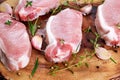 Raw Fresh Boneless Pork Chops with herbs. on wooden board. Royalty Free Stock Photo