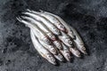 Raw fresh capelin fish. Black background. Top view