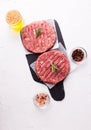 Raw fresh hamburger patties or cutlet ready to cook on white textured background. Royalty Free Stock Photo