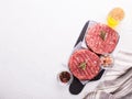 Raw fresh hamburger patties or cutlet ready to cook on white textured background. Royalty Free Stock Photo