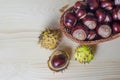 Raw fresh inshell chestnuts in basket on wooden background. traditional dishes for christmas and halloween. Royalty Free Stock Photo