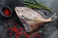 Raw fresh John Dory fish with pink pepper and thyme. Black background. Top view