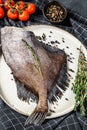 Raw fresh John Dory fish with pink pepper and thyme. Black background. Top view Royalty Free Stock Photo