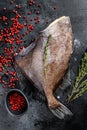 Raw fresh John Dory fish with pink pepper and thyme. Black background. Top view Royalty Free Stock Photo