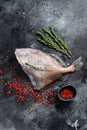 Raw fresh John Dory fish with pink pepper and thyme. Black background. Top view