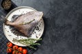 Raw fresh John Dory fish with pink pepper and thyme. Black background. Top view. Copy space Royalty Free Stock Photo