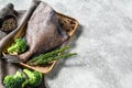 Raw fresh John Dory fish on a wooden tray with rosemary and broccoli. Gray background. Top view. Copy space