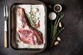 Raw fresh Lamb Meat in baking tray, herbs and fork on black stone background Royalty Free Stock Photo