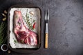 Raw fresh Lamb Meat shank, herbs and fork on black stone background Royalty Free Stock Photo