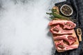 Raw fresh lamb ribs with pepper and thyme. Organic meat. White background. Top view. Copy space Royalty Free Stock Photo