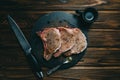 Raw fresh meat Pork steak and seasonings on dark wooden background board slate with honey knife