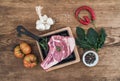 Raw fresh meat ribeye steak with pepper, salt, chili, garlic, spinach, heirloom tomatoes and rosemary in cooking pan