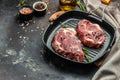 Raw fresh meat steaks on frying pan on a dark background. banner, menu, recipe place for text, top view Royalty Free Stock Photo