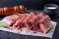 Raw fresh meat, uncooked lamb or beef ribs with pepper, garlic, salt, bay leaves and spices on dark stone background, Ready for Royalty Free Stock Photo