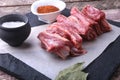 Raw fresh meat, uncooked lamb or beef ribs with pepper, garlic, salt and spices on dark stone background, Ready for Royalty Free Stock Photo