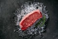 Raw fresh New York beef steak on ice with herbs