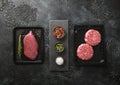 Raw fresh organic beef sirloin fillet steak and mince burgers sealed in vacuum tray with on black background with spices Royalty Free Stock Photo