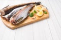 Raw fresh Pollock fish on a wooden Board with lemon Copy space