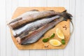 Raw fresh Pollock fish on a wooden Board with lemon