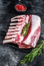 Raw fresh rack of lamb meat on marble board. Black background. Top view Royalty Free Stock Photo