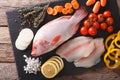 Raw fresh red tilapia and vegetables, spices close-up on a cutting board. Horizontal top view Royalty Free Stock Photo