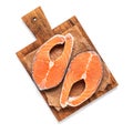 Raw fresh salmon steaks on a wooden cutting board isolated on a white background. Top view, flat lay Royalty Free Stock Photo