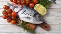 Raw fresh uncooked dorado or sea bream fish with lemon, herbs,  cherry tomatoes and spices on white background Royalty Free Stock Photo