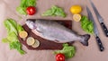 Raw fresh unprepared salmon fish on a wooden board with ingredients for cooking.