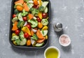 Raw fresh vegetables on a baking sheet. Sweet potato, zucchini, sweet pepper, cherry tomatoes, garlic, broccoli cabbage, olive oil Royalty Free Stock Photo