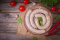 Raw fresh white sausages on a plate with vegetables. Weisswurst in a heap. Traditional Bavarian or Munich white sausage made from Royalty Free Stock Photo