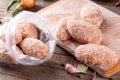 Raw Frozen lazy cabbage rolls lie on a wooden board on the kitchen table with vegetables. Frozen food Royalty Free Stock Photo