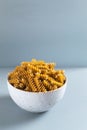 Raw fusilli pasta in a white bowl on a gray background. Royalty Free Stock Photo