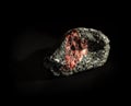 Raw garnet almandine stone crystal inside granite rock isolated on black. Found in Kem, Karelia, Russia. For geology Royalty Free Stock Photo